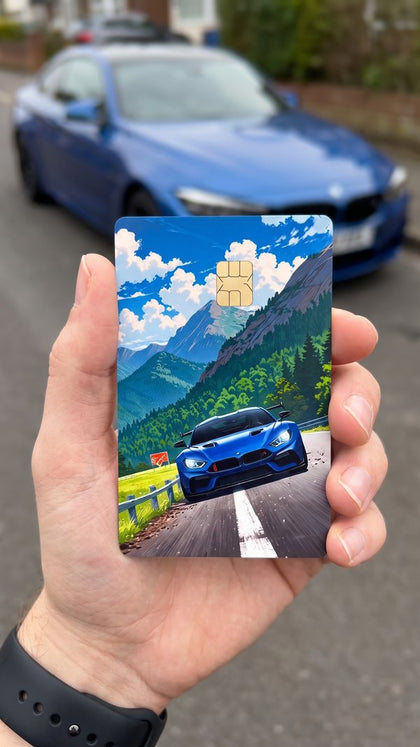 A personalized car card sticker held up, blue sports car